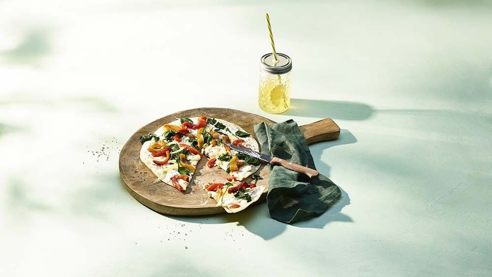 Pain plat avec des poivrons grillés et des épinards