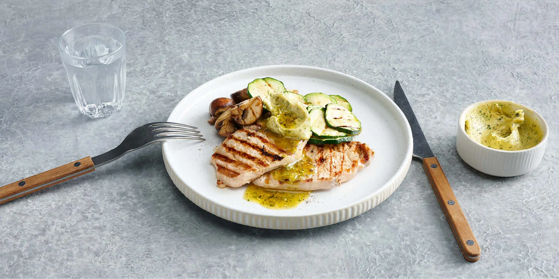 Scaloppine di maiale con verdure alla griglia e burro alle erbe aromatiche